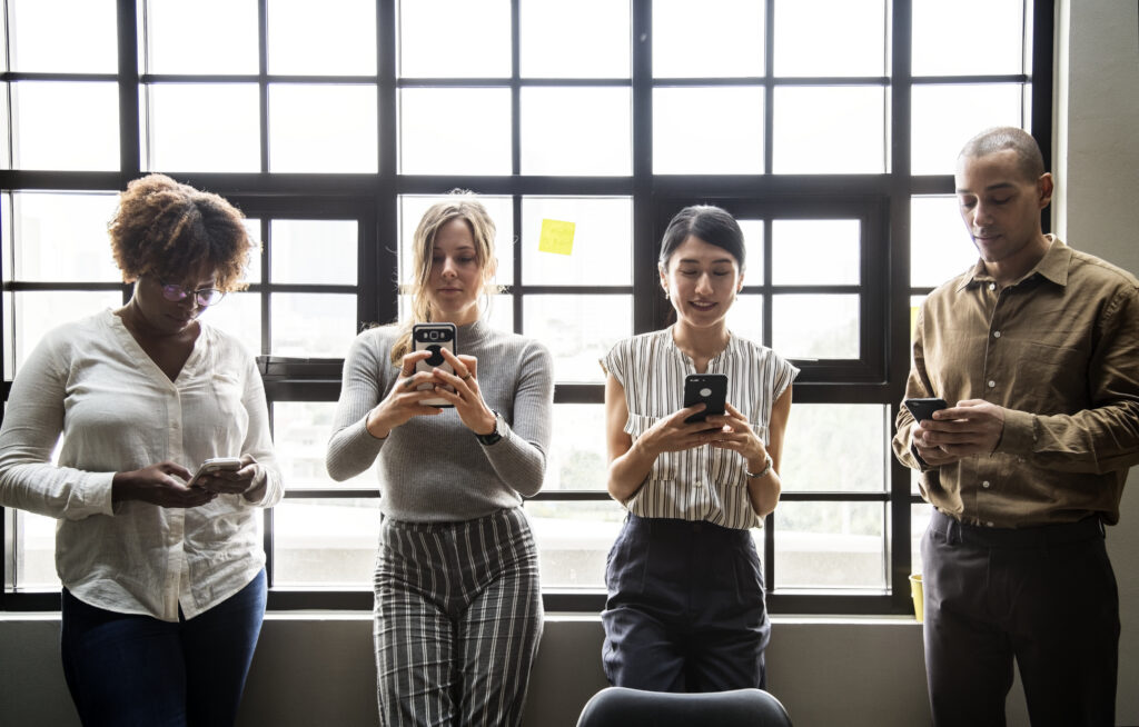 Four people using smart phones